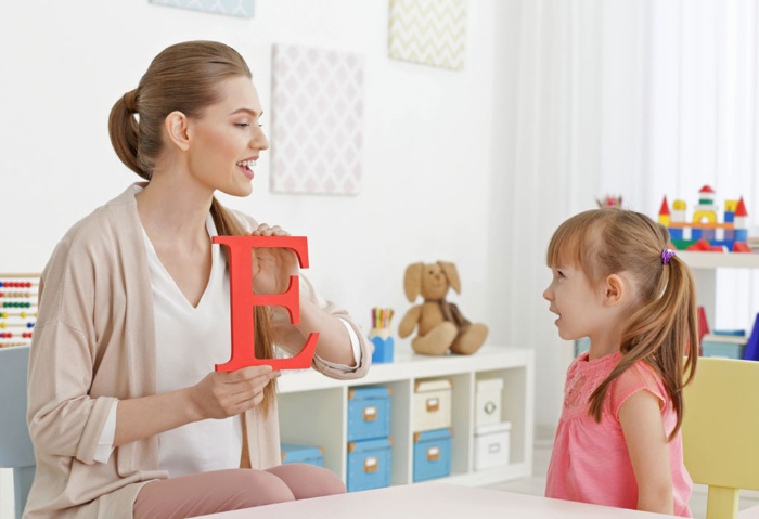 learning with kids mom teaching her little girl the alphabet showing her the letter E