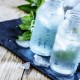 Very cold mineral water with ice in a misted glass bottles, dark background, selective focus