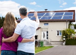 Rear View Of Couple Standing In Front Of Their House