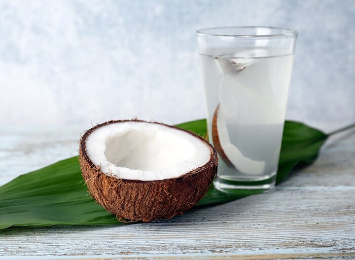 coconut water for optimal hydration half a coconut and a glass of water with a coconut leaf