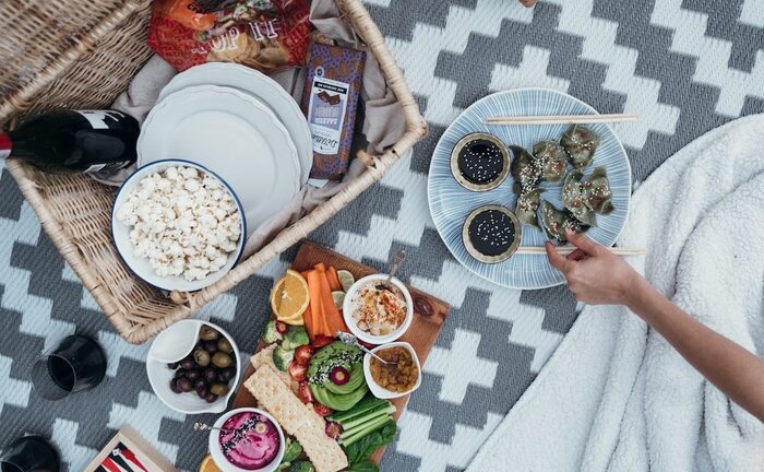 delicious snacks for summer picnic person sitting on a blanket snacking on picnic food