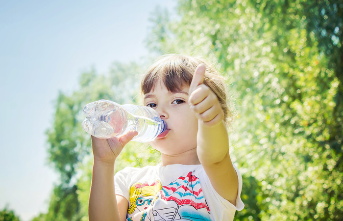 drink water hydration little girl drinking water from a bottle showing thumbs up