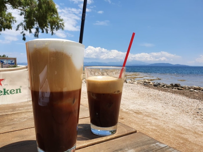 greek frappe on a wooden table on the beach frappe in glasses with straws