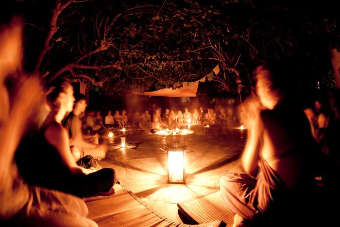 ritual people sitting around lanterns at night celebrating the summer solstice