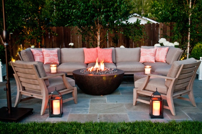 living room outdoors with a fire pit lanterns chairs and a sofa