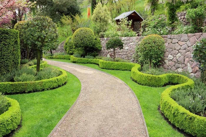 long garden walkway surrounded by green trees and bushes