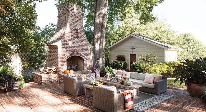 outdoor living room with a huge fireplace and a sitting area with sofa and chairs