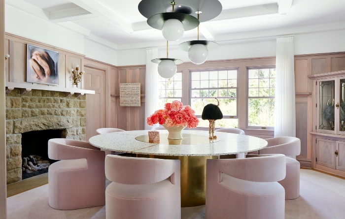 pink interior feminine style with stone table and bright floral centerpiece modern lighting