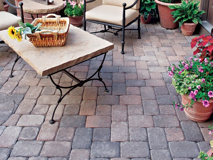 paved porch with a stone table and vintage wrought iron furniture and flowers