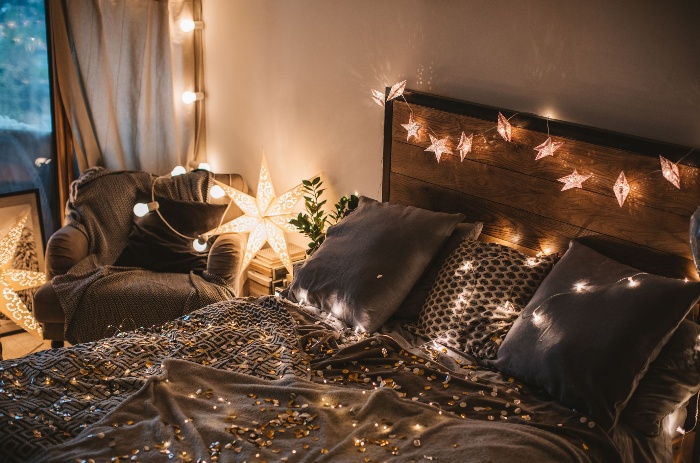 romantic lights in a dark bedroom on a bed and sofa