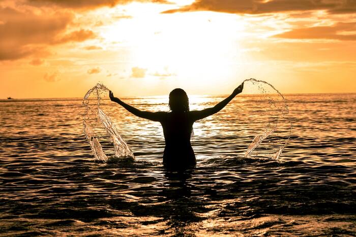 swimming sunset woman in the sea at sunset