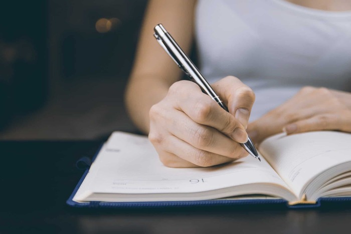 woman planning with a pen and a note writing and planning
