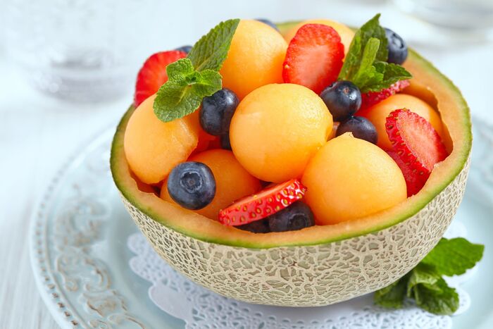 cooling summer dessert fruits in half a melon on a white plate