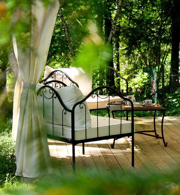 afternoon tea garden relaxation spot with benches and a coffee table surrounded by trees