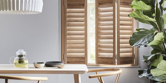 airy summer interior with wooden elements table chairs and shutters