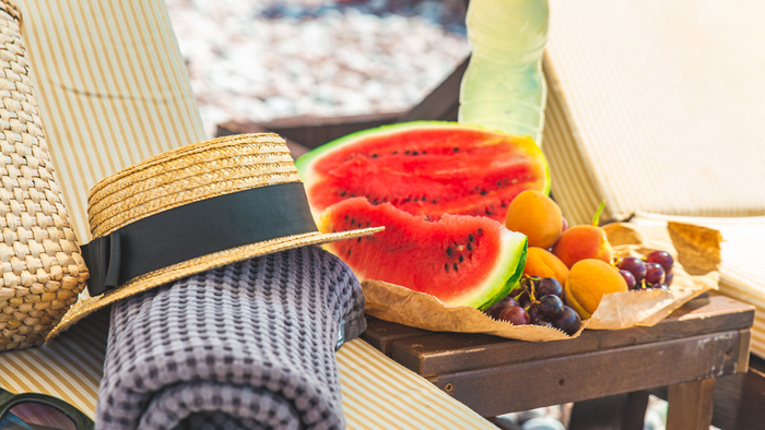 beach accessories sun hat towel summer bag and fruits