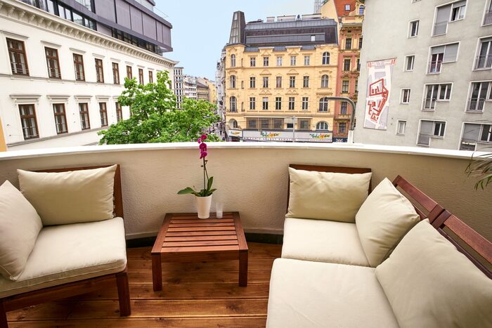 city balcony minimal design with wooden floor beige sofas small wooden table and a nice view