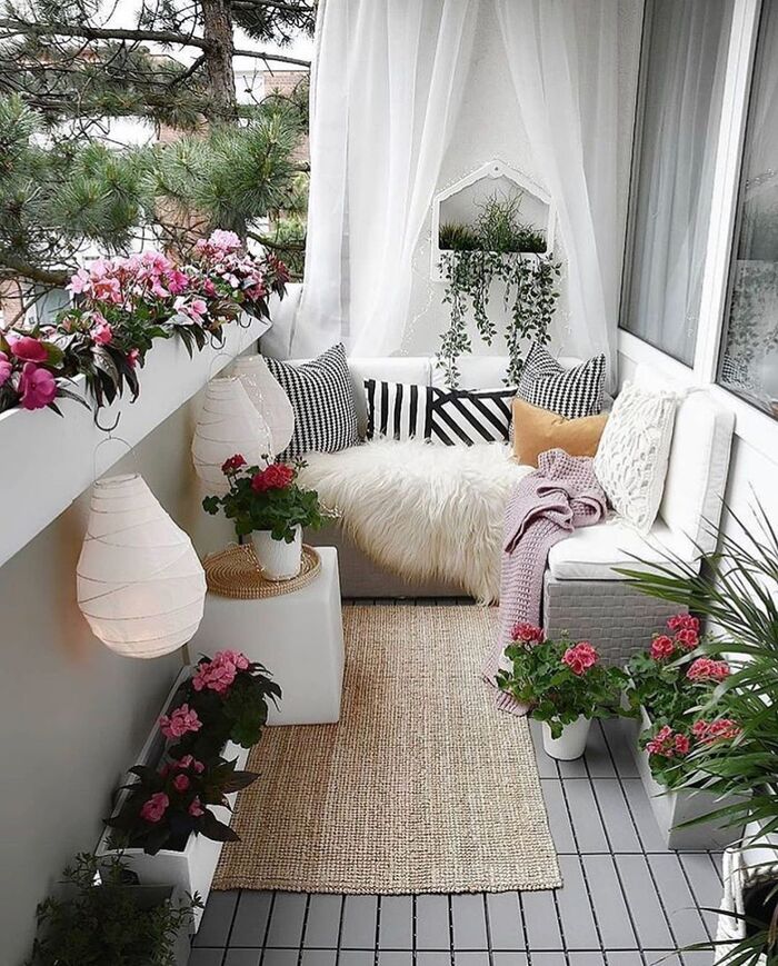 cute small urban balcony with living flowers lanterns and a seating area grey tiled floor