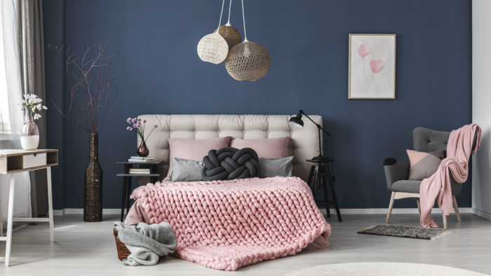 Statement decor pieces pink knit blanket modern light fixture and dark blue wall