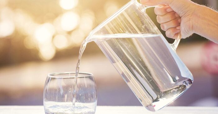 drink water hand pouring water from a jug into a glass