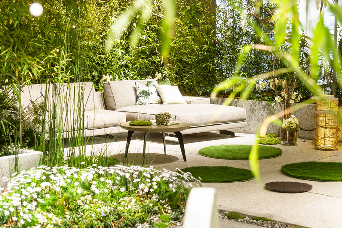 modern garden relax area with a light sofa bamboo and other greenery