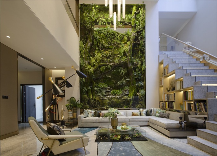 green living room design with a tall green living wall white staircase and modern furniture