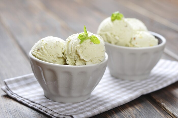 cooling dessert vanilla ice cream with la little mint in ceramic bowl on wooden background