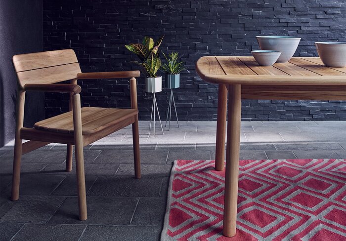 japandi outdoor dining area with a wooden chair and table simple red carpet and dark walls