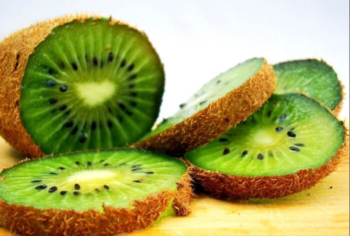 kiwis sliced green kiwi on a table with light background