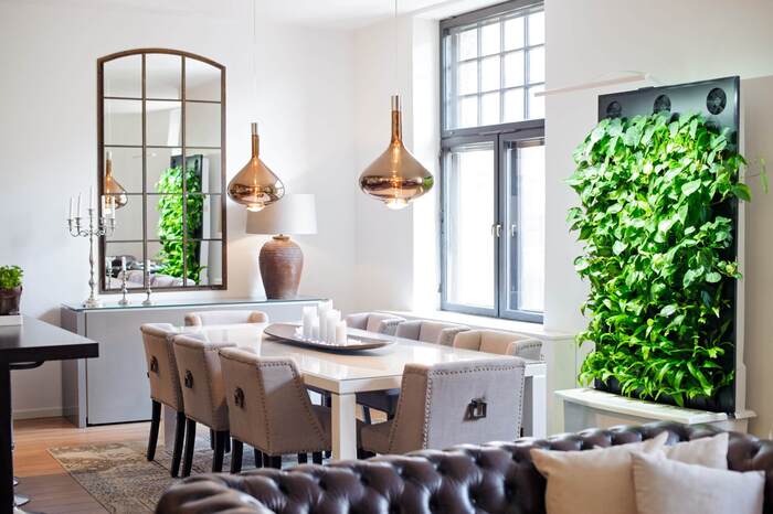 modern dining space with a green wall metallic lights and natural light