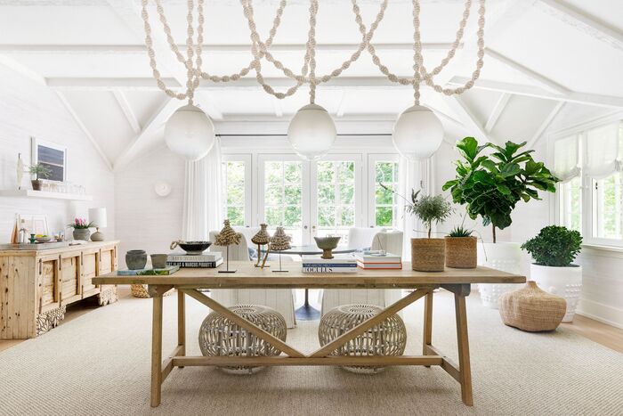Home Design Summer Trends white spacious and airy living room space with modern light fixtures and a wooden table