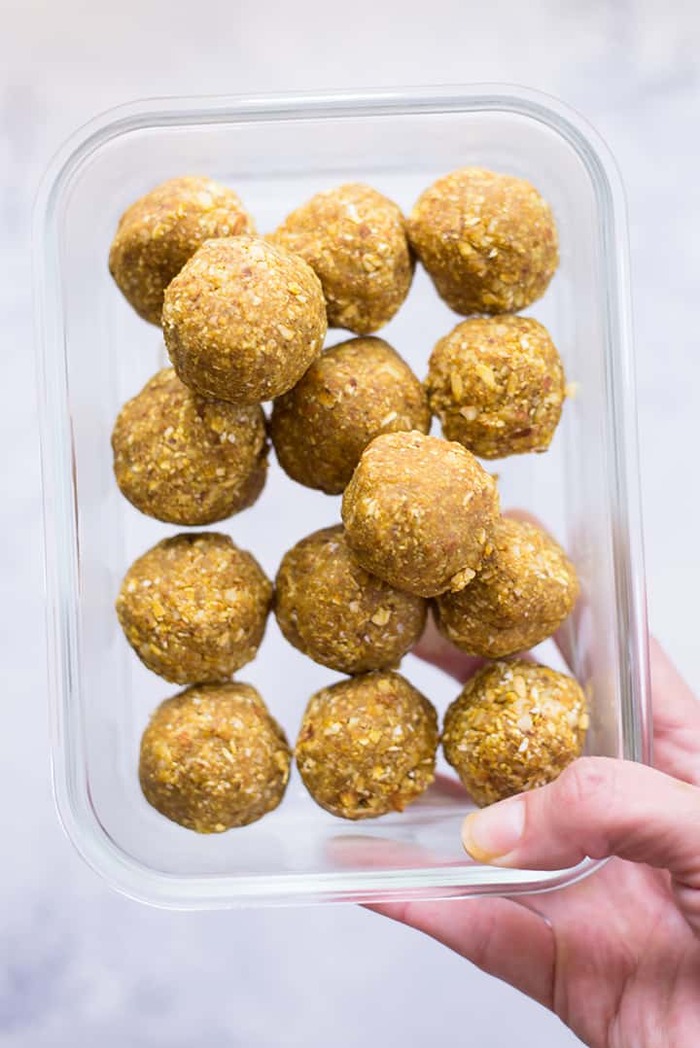 protein candy balls in a glass container woman holding it in her hand