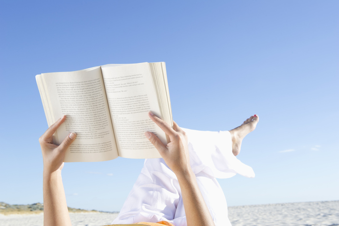 beach reading list woman dressed in white on the beach reading a book