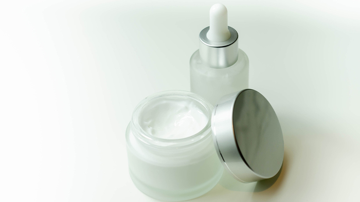 retinol cosmetics a cream jar and a glass bottle with a pipette on a white background