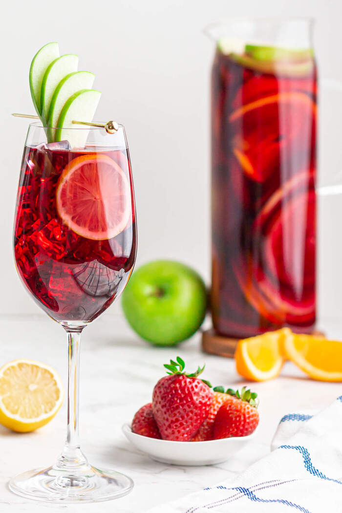 sangria in a glass with apple slices and different fruits