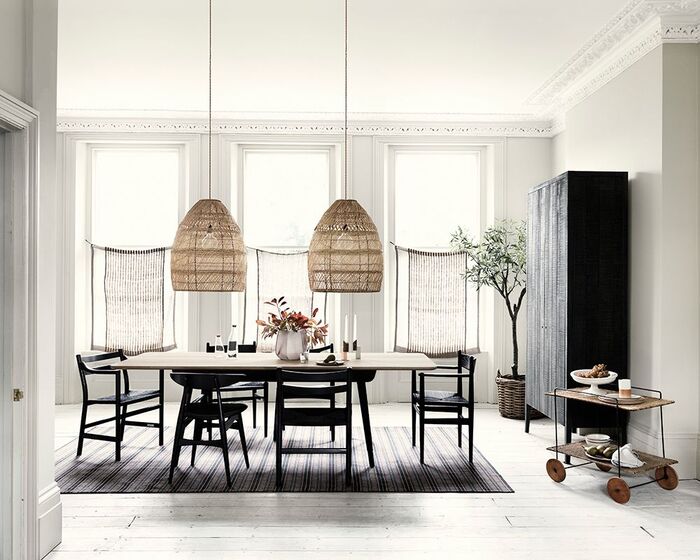 simple japandi style dining space with natural materials two lighting fixtures and dark furniture