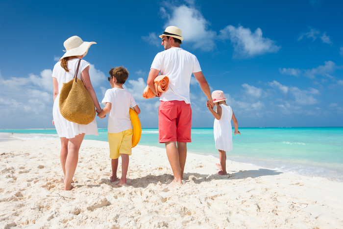 summer vacation family of four on the beach couple with two children