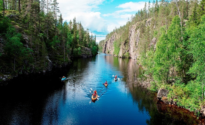 the wild taiga finland kayaking trip down a river amidst forests and rock cliffs