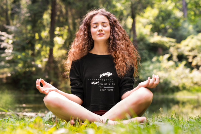 woman meditating outdoors in the garden surrounded by trees and plants