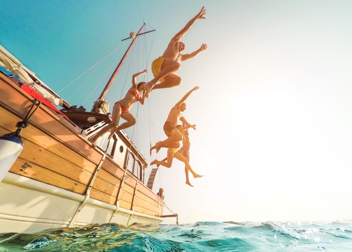 yachting journeys friends jumping in the water from a boat sea journeys yachting