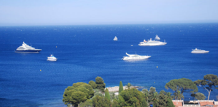 white yachts in a blue sea just off the coast