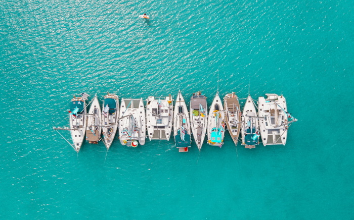 yachts in the sea parked next to each other in a bright blue water