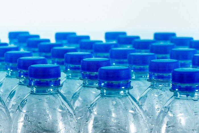 bottles of water with blue caps in several rows