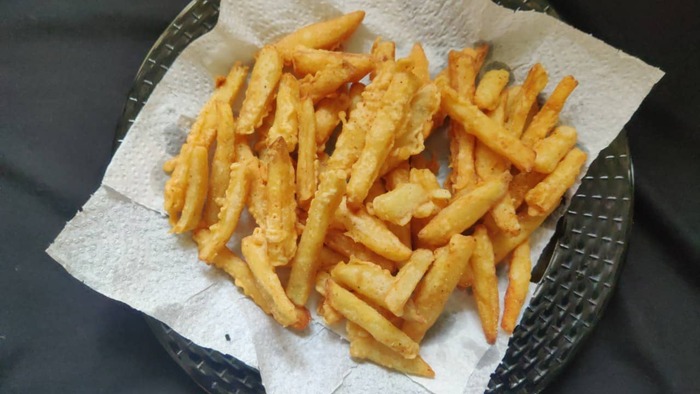 french fries on a white piece of paper with honey topping