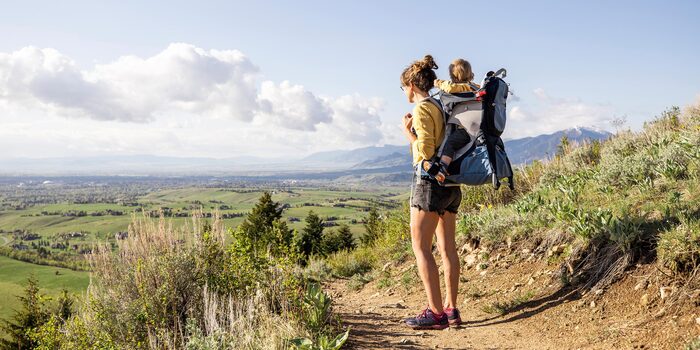 hiking with a baby women in shorts hiking with a baby on her back in a baby chair