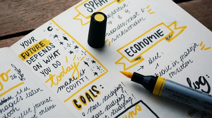 journaling notebook with a yellow pen and colorful journaling notes for goals and planning