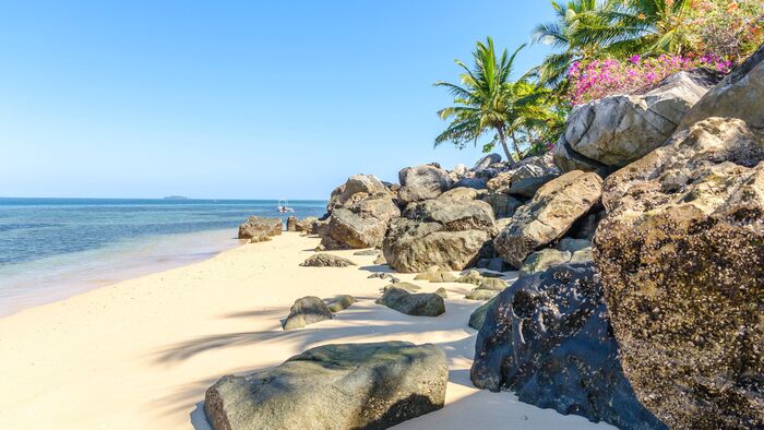 madagaskar beach with large rocks and palm trees on top
