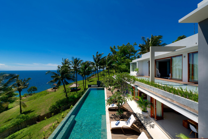 malibu cliff villa modern exterior long outdoor pool on a cliff with green grass and palm trees