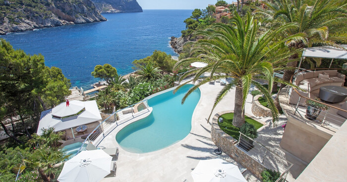 mallorca spain villa with an outdoor pool and a large palm tree overlooking the sea tropical landscape