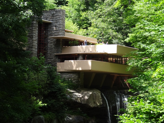 modern structure iconic waterfall house surrounded by green trees and nature